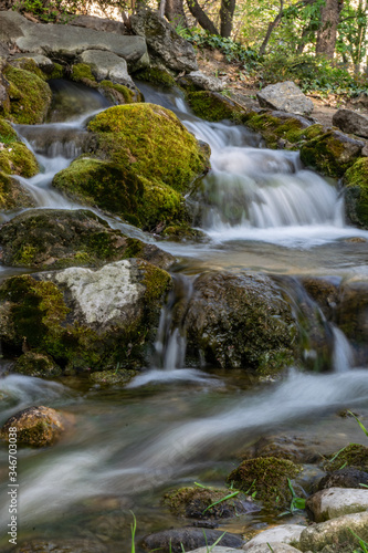 Fototapeta Naklejka Na Ścianę i Meble -  Small mountain waterfall with moss covered rocks in the forest