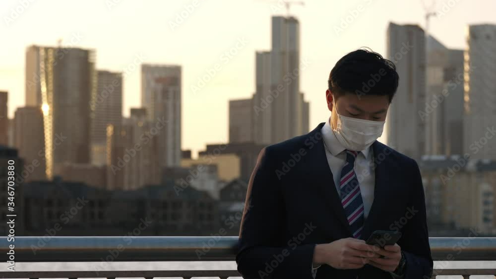 Asian man texting on phone during Coronavirus pandemic Asian man texting on phone during Coronavirus pandemic