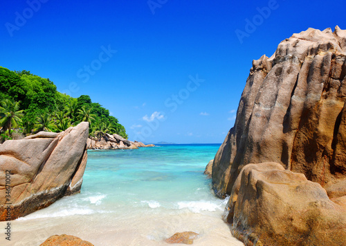 Large granite rocks in Anse Patates beach, La Digue Island, Indian ocean, Seychelles. Beautiful tropical landscape with sunny sky.