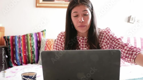 Hispanic woman blowing her nose and coughing heavily, recovering from coronavirus and working from home photo