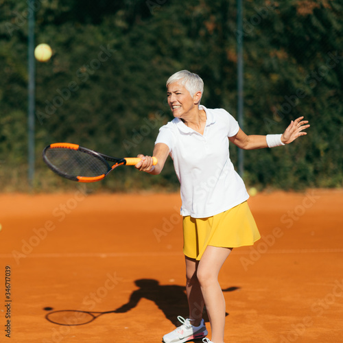 Beautiful Sporty Senior Woman at Outdoor Tennis Class © Microgen