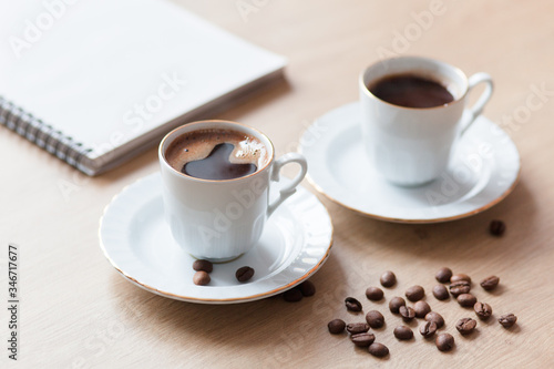 Two cup of turkish coffee close-up on a wooden background, coffee beans. Pleasant morning and cheerfulness