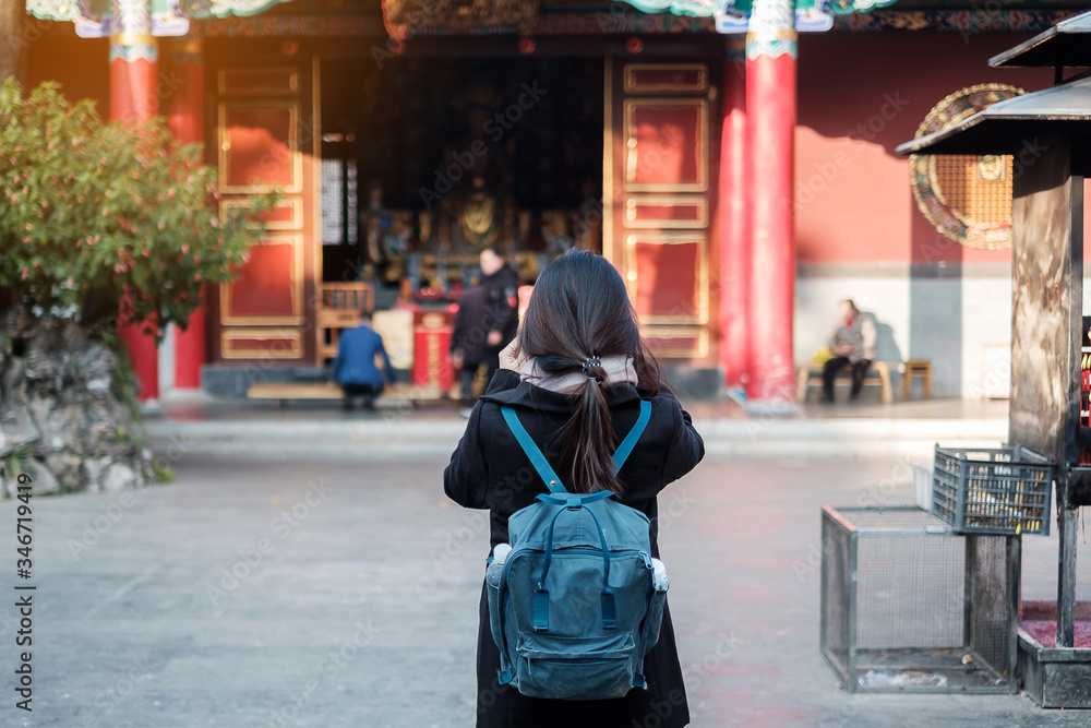 Young woman traveler hand holding incense in Yuantong Temple, Buddhist temple in Kunming. landmark and popular for tourists attractions in Kunming, Yunnan, China. Asia travel concept