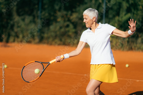 Active Lifestyle Seniors – Positive Mature Woman Playing Tennis Recreationally © Microgen