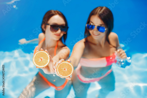 Beautiful girls on a vacation. Friends in the swimming pool