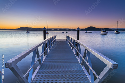 Sunrise, boats and wharf waterscape © Merrillie