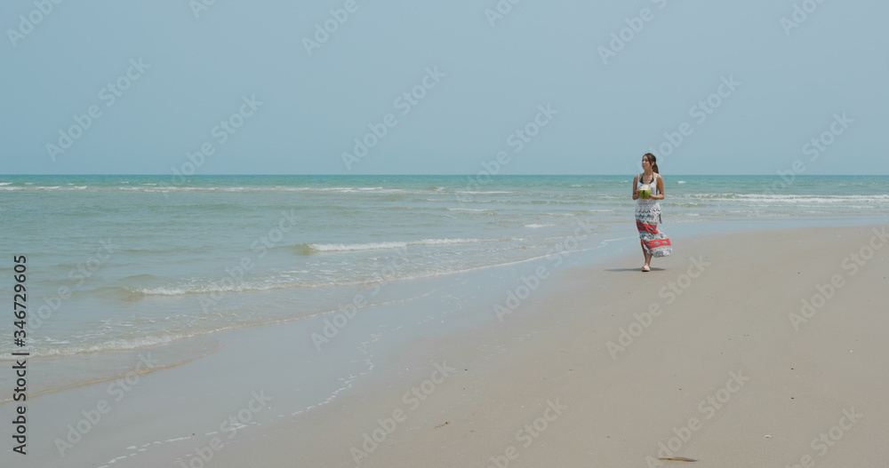 Woman drink of coconut and walk on the beach Woman drink of coconut and walk on the beach