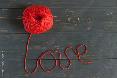 the word love is made of red yarn on a wooden table photo