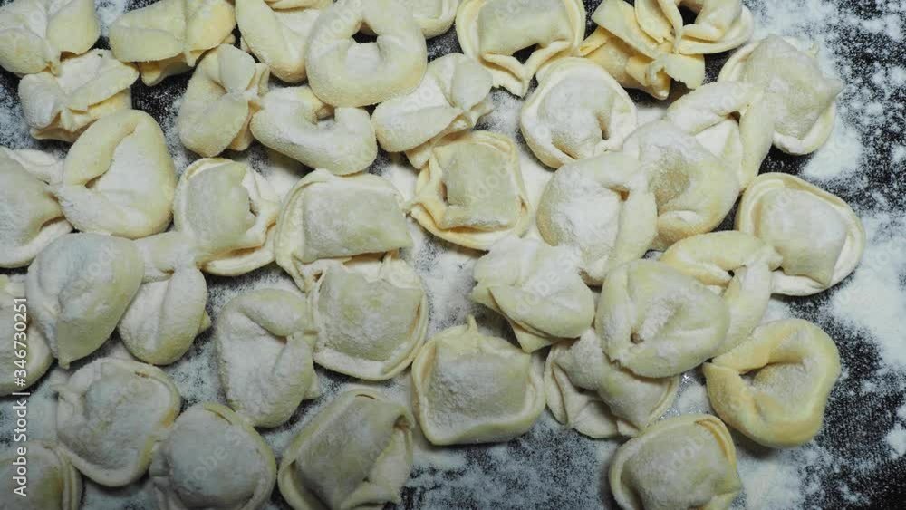 Delicious tortellini a ring-shaped pasta from Italy. Traditionally they are stuffed with a mix of meat, parmigiano reggiano cheese, egg and nutmeg. Black background Delicious tortellini a ring-shaped pasta from Italy. Traditionally they are stuffed with a mix of meat, parmigiano reggiano cheese, egg and nutmeg. Black background