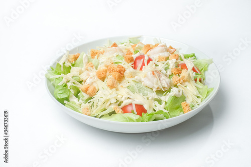 light summer salad in a white plate on a white background