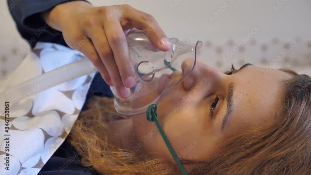 Girl with oxygen mask in the bed. This footage can be used to show respiratory problems like severe cold, allergy or asthma.