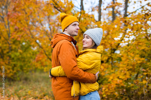 cute couple in love embracing over autumn forest background
