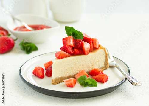 Slice of cheesecake with strawberries, mint and sauce. Selective focus
