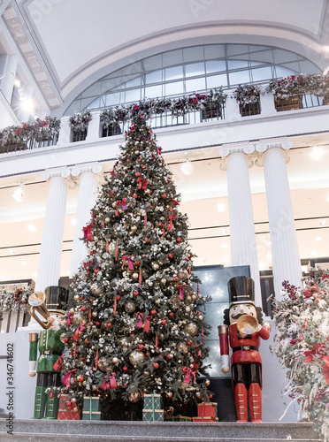 a large beautiful Christmas tree with balls and two huge nutcrackers in a shopping center. New Year.