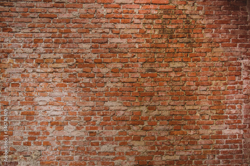 Old brick wall with visible cement stains and leftovers on the bricks. Red brick wall.