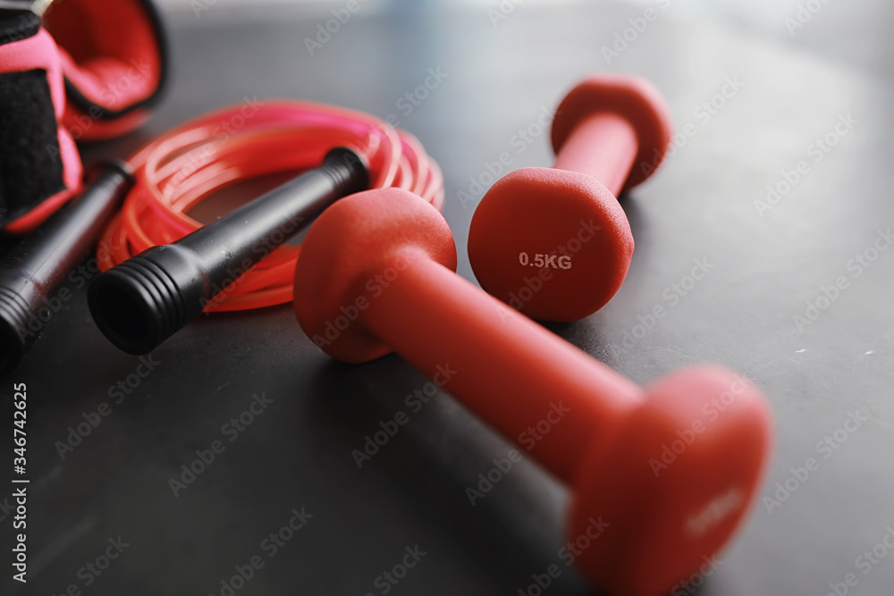 Sport and healthy lifestyle. Accessories for sports. Yoga mat dumbbell and jump rope. Sports background home exercises concept. Sport and healthy lifestyle. Accessories for sports. Yoga mat dumbbell and jump rope. Sports background home exercises concept.