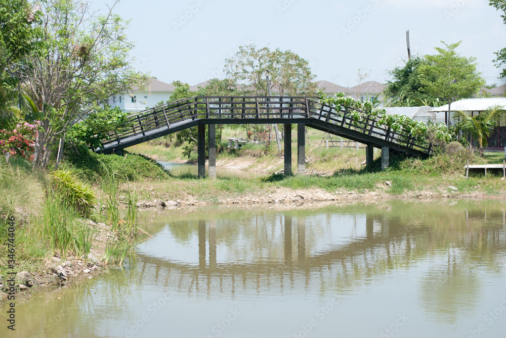 Arched wooden bridge and reflections on the water surface Arched wooden bridge and reflections on the water surface