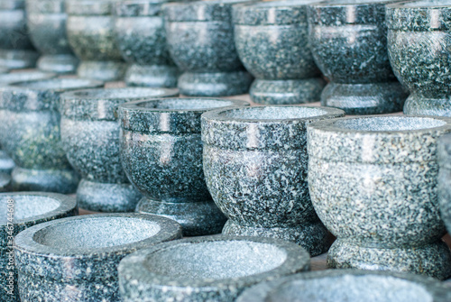 Stone mortars lined up in front of the Angsila shop. Chonburi Province © Kritkamon