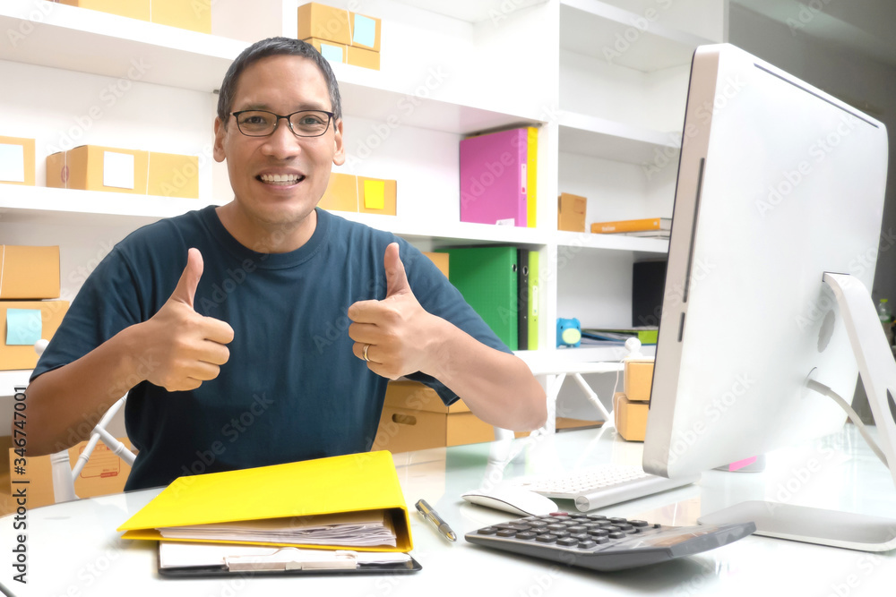 Asian mature man work from home thumbs up with computer feeling exited, successful in online social media shopping business