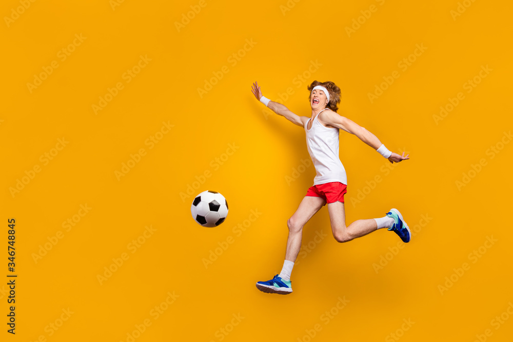Full length body size view of his he nice funky carefree cheerful cheery glad motivated guy jumping playing soccer having fun isolated over bright vivid shine vibrant yellow color background