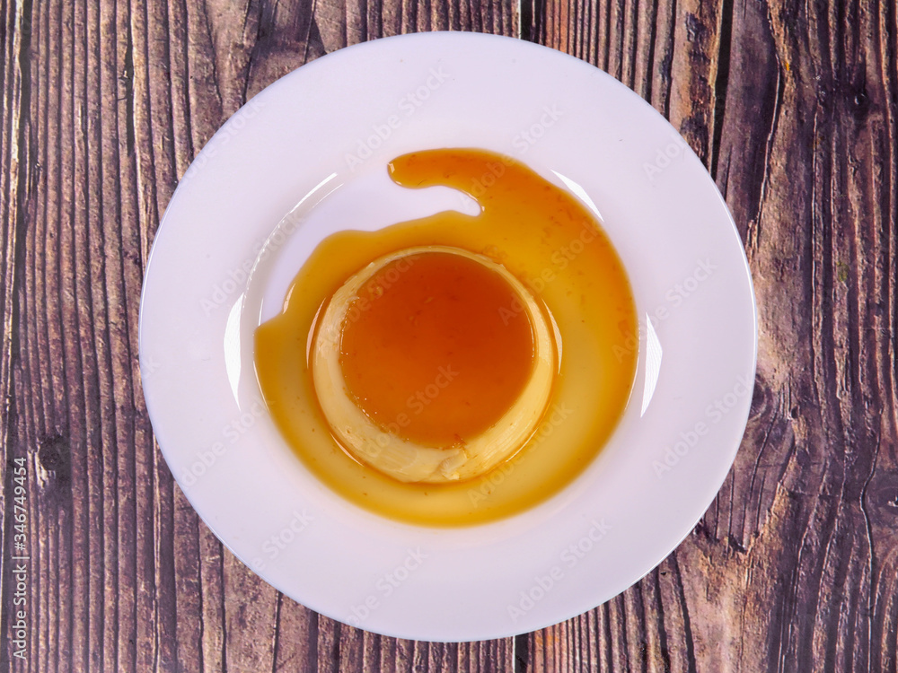 Tasty caramel custard with eggs, milk, and sugar on a plate. top view Tasty caramel custard with eggs, milk, and sugar on a plate. top view