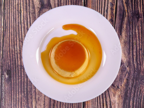Tasty caramel custard with eggs, milk, and sugar on a plate. top view