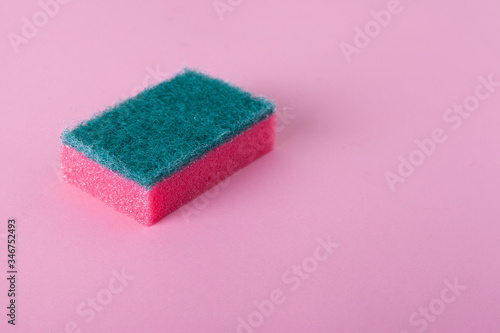 Kitchen cleaning sponge on pink background with copy space. 