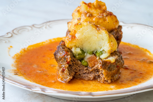 Turkish Food Hasanpasa Kofte / Kofta with Puree / Meatball with Bechamel, Tomato Paste Sauce and Green Peas. photo