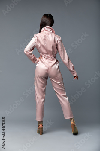 фотографія beautiful girls modeling with fashion pink jumpsuit dress and clothes wearing white high heels, gray background