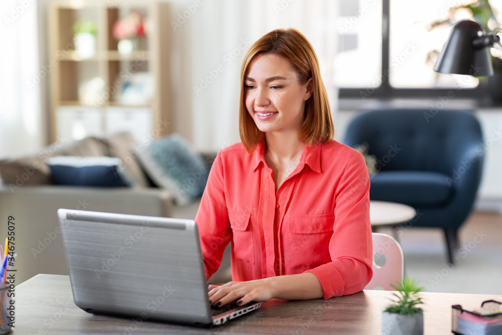 remote job, technology and people concept - happy smiling young woman with laptop computer working at home office remote job, technology and people concept - happy smiling young woman with laptop computer working at home office