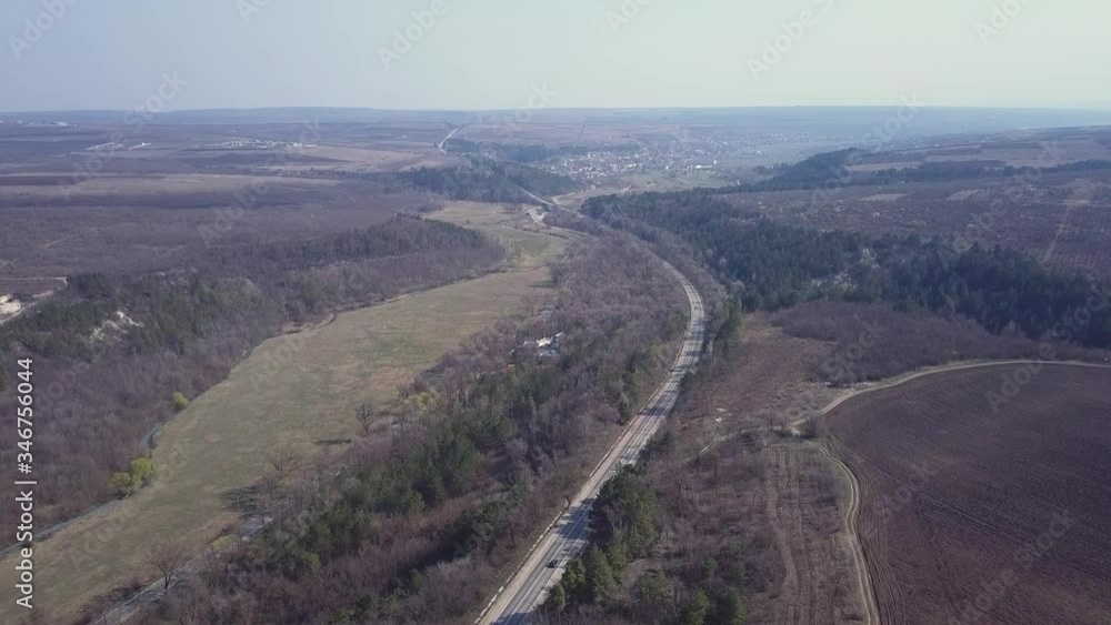 AERIAL 4K: Flight Over Road Running Through Forest. DRONE View at misty hills with country road. Cinematic shot. Early sprimg. AERIAL 4K: Flight Over Road Running Through Forest. DRONE View at misty hills with country road. Cinematic shot. Early sprimg.
