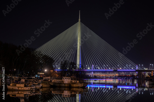 Ada bridge illuminated at night with beautiful water reflection, famous Belgrade landmark