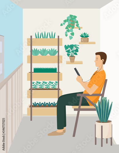 A young man sits sideways in a chair and looks at a tablet. A person on the balcony with headphones, listening to music or reading. Flat vector illustration.