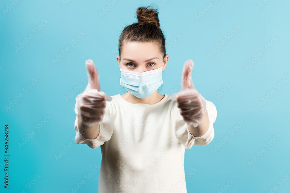 woman in protective medical mask shows thumbs up with hands in medical gloves woman in protective medical mask shows thumbs up with hands in medical gloves