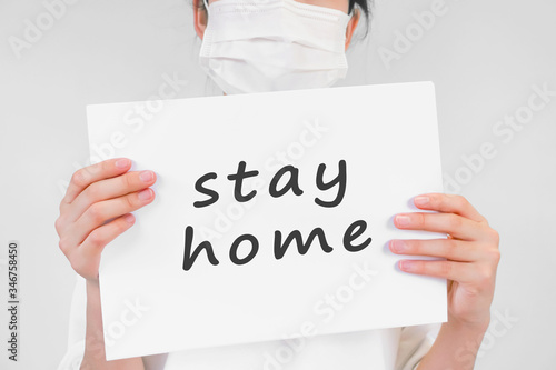 Person with board written as stay home ステイホームと書かれたボードを持つ人