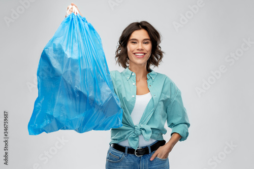 Obraz na plátně waste sorting and sustainability concept - smiling young woman holding plastic t