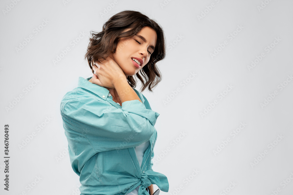 © Syda Productions - people concept - young woman in turquoise shirt suffering from neck ache over grey background © Syda Productions - people concept - young woman in turquoise shirt suffering from neck ache over grey background