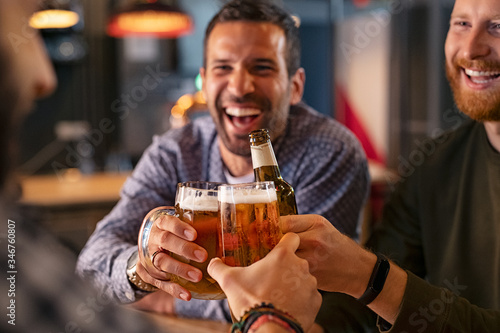 Fotografia Friends toasting beer glass and bottle