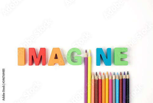  " IMAGINE " Multicolored Wooden Letters with Multicolored Pencil on White Background 