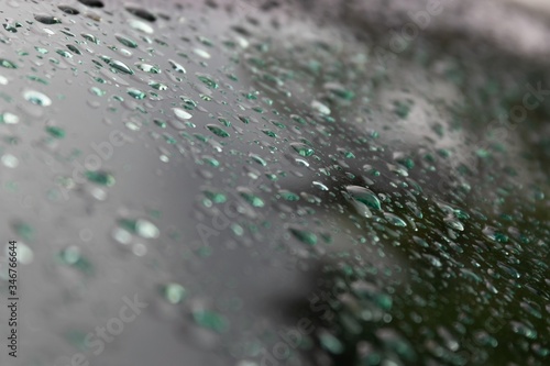 Background of raindrops on car glass at dusk