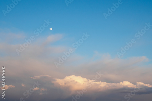 Cirrocumulus and cumulus clouds and full moon on blue sky background