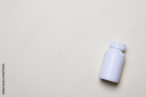 White plastic medical container for pills on right side of yellow background with copy space