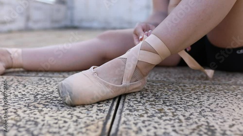 Ballerina tying her shoes to start dancing ballet