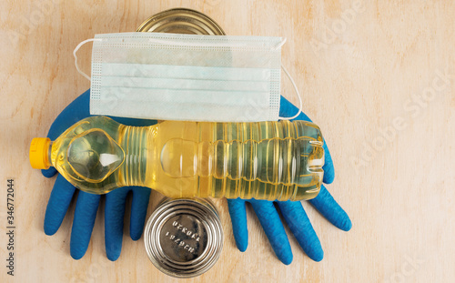 Blue medical gloves and medical mask with food donation products.