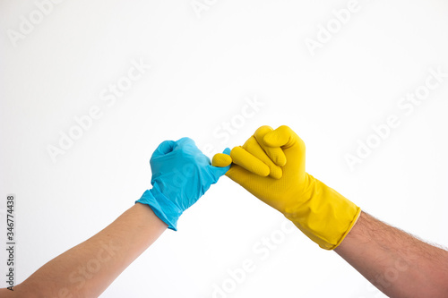 Caucasian woman and man hands and arms in blue and yellow latex gloves doing the pinky swear sign isolate on white