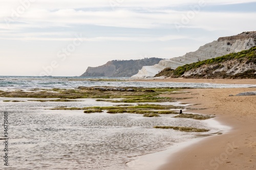 Sandy beach at Scala dei Turchi (Stair of the Turks) near Argigento, Sicily during the beautiful sunset with stones covered by green moss