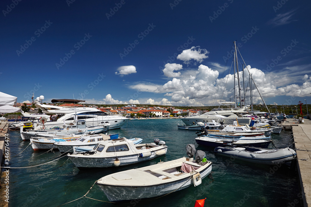 many white yachts and boats at the pier against the blue sky