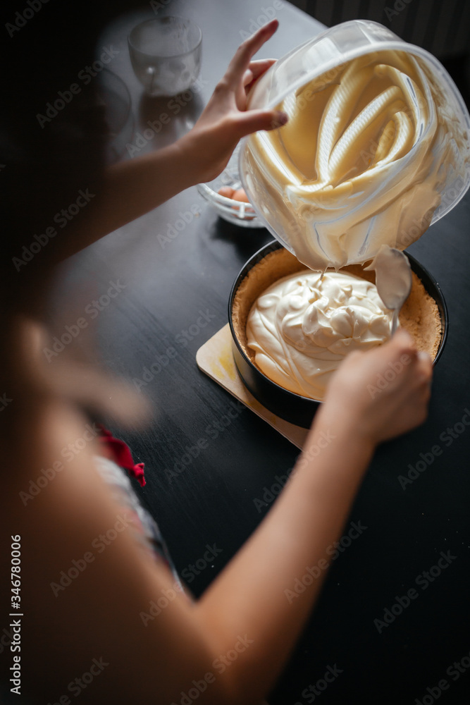 beautiful girl puts food in a baking dish in the kitchen beautiful girl puts food in a baking dish in the kitchen