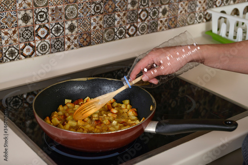 Cook has found a way to keep her arm unharmed from hot oil drops by creating an improvised armor from a plastic bottle. photo