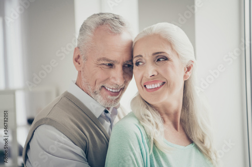 Close up photo of lovely grandparents true lovers looking wearing teal brown sweaters in apartment